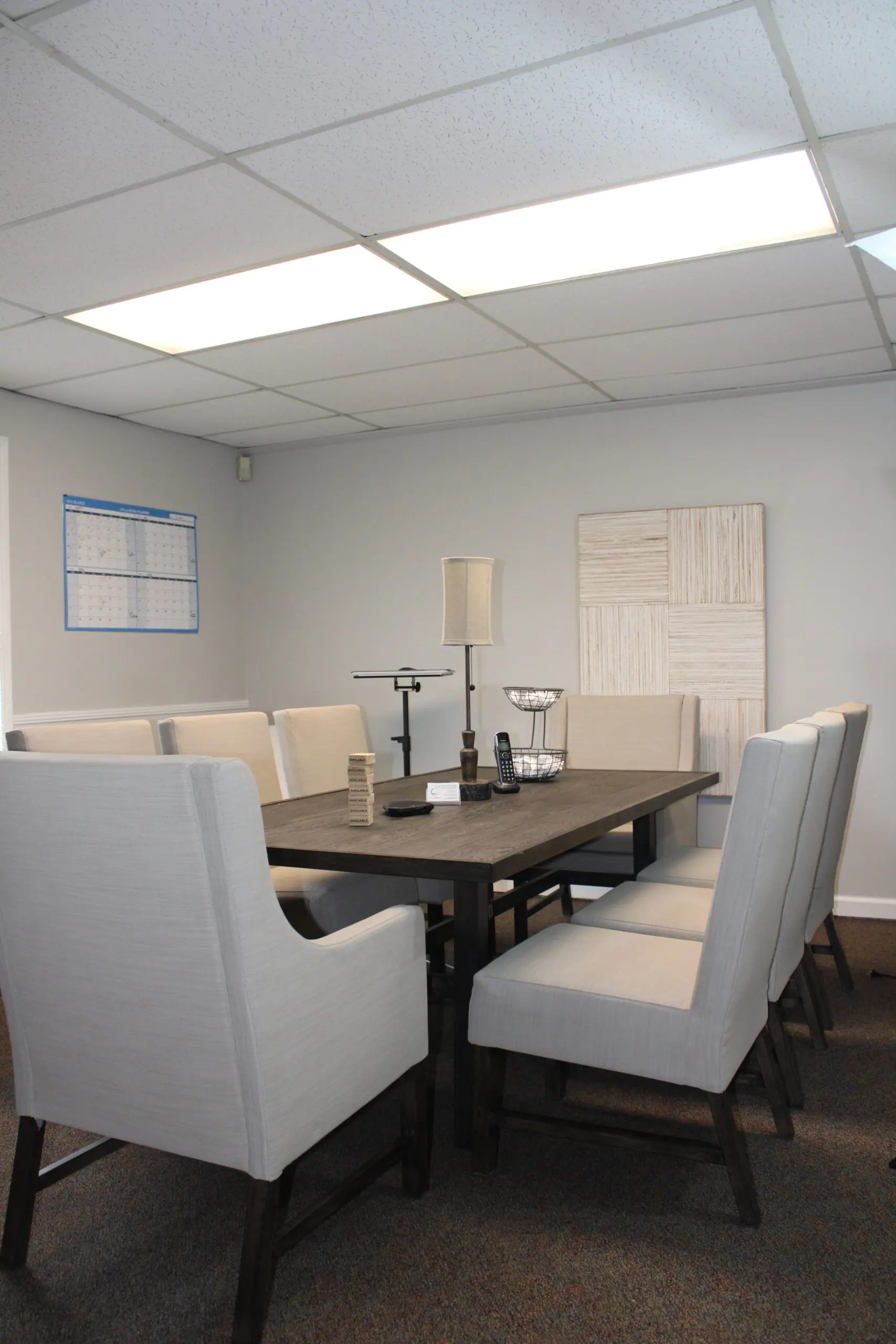 A large table with white chairs in front of it.