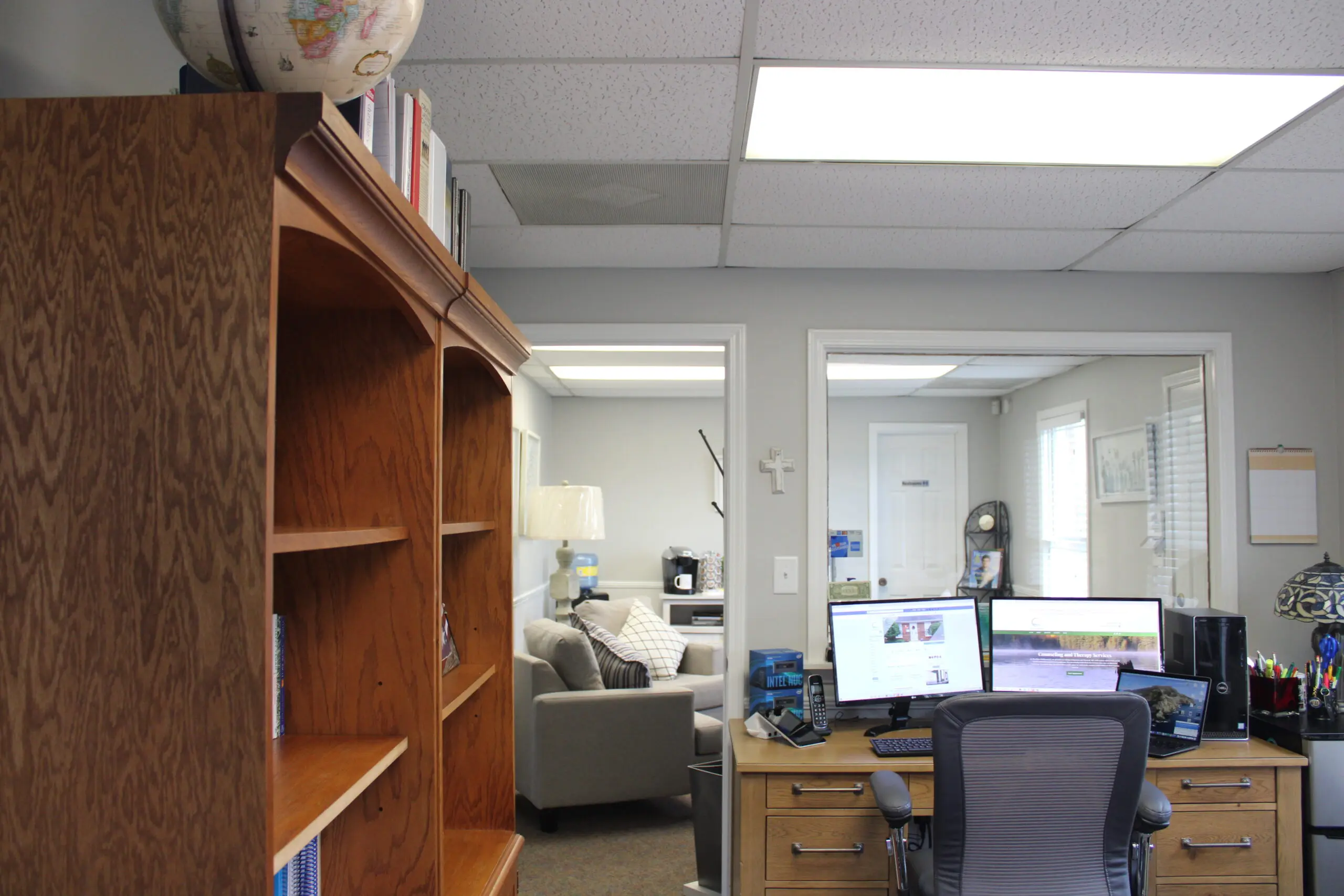 A room with two computers and a desk.