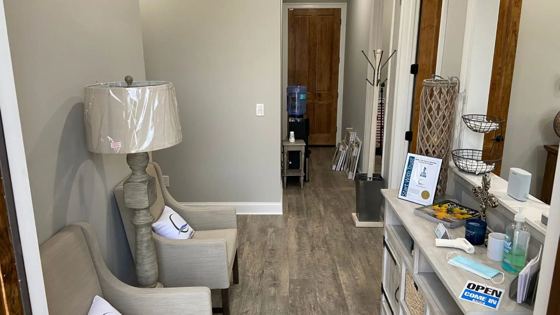 A living room with hard wood floors and a white desk.