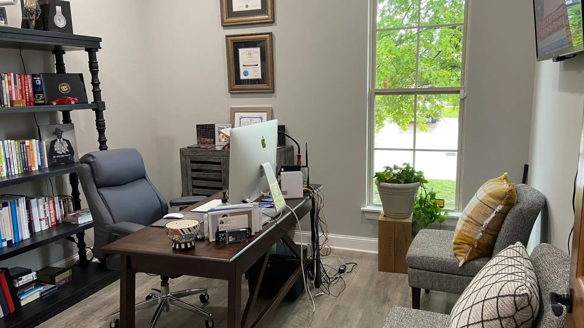 A room with a desk, chair and computer.